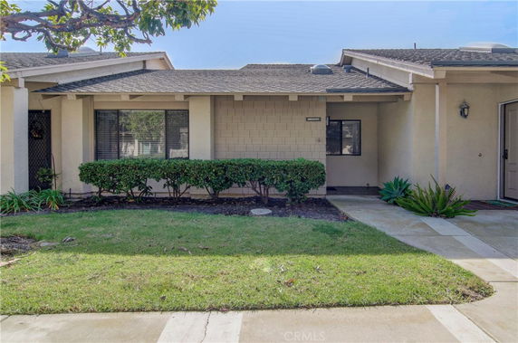 Front view of a single-story house with a low-pitched roof and landscaping.