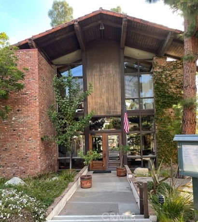 Front view of a two-story building with brick walls and large glass windows.