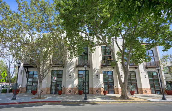 Front view of a multi-story building with large windows and balconies.