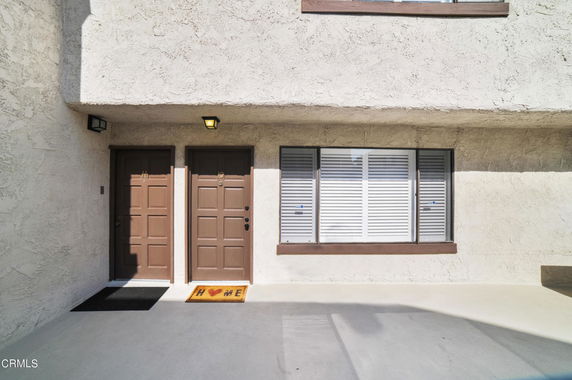 Front view of a building entrance with two doors and a window.