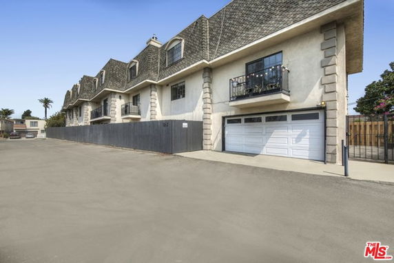 Front view of a multi-story residential building with garage doors.