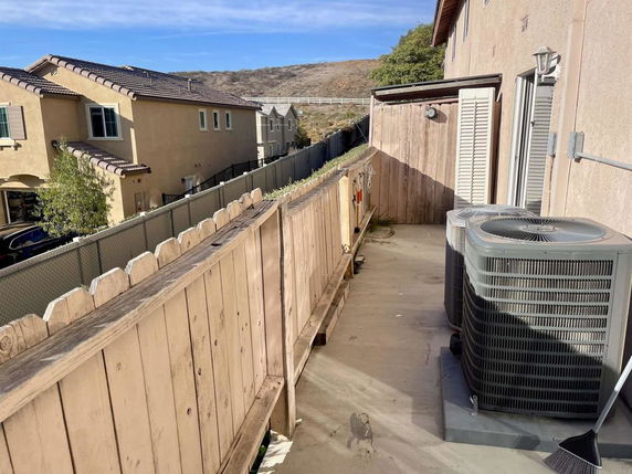 Rooftop area with wooden fencing and air conditioning units.