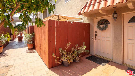 Entrance view of a house with a decorated door and terracotta roof tiles.
