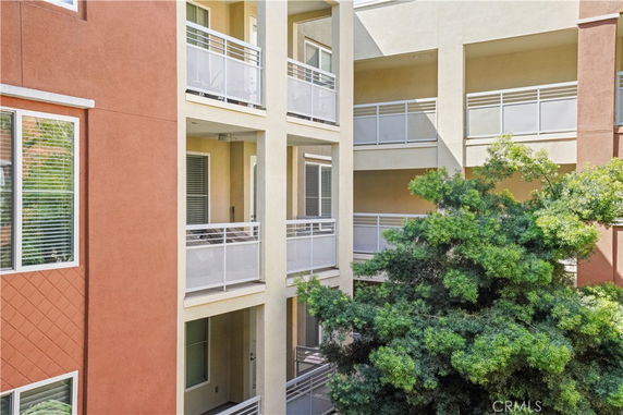 Front view of a multi-story building with balconies and large windows.