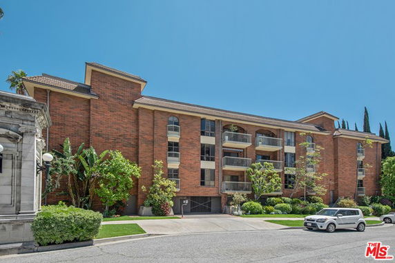 Front view of a multi-story brick building with balconies.