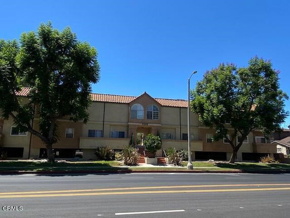Front view of a multi-story apartment building with symmetrical windows and a central entrance.