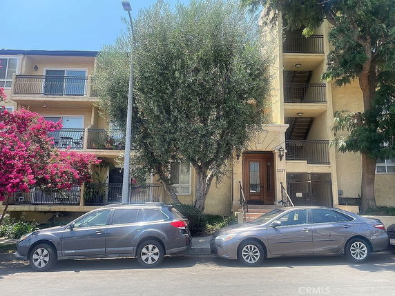 Front view of a multi-story residential building with balconies.