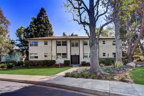 Front view of a two-story apartment building with a central entrance and multiple windows.
