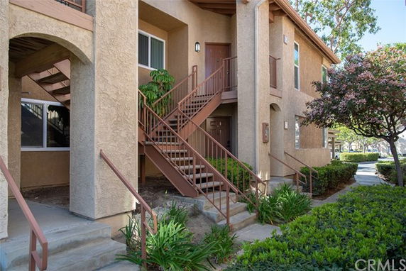 Front view of a two-story apartment building with an external staircase.