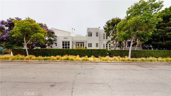 Front view of a modern two-story building with white exterior and multiple windows.