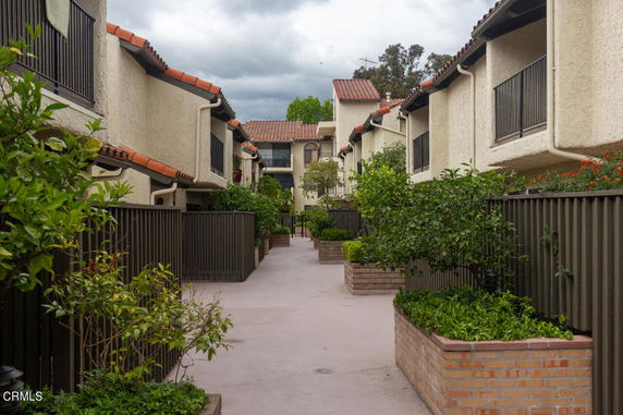 View of a residential complex with two-story buildings and a central walkway.