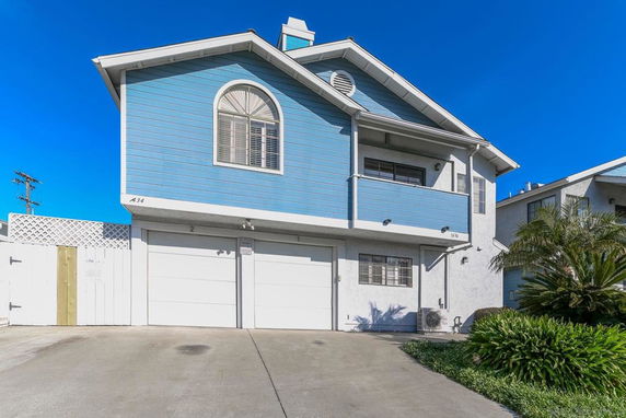 Front view of a blue two-story house with a double garage.