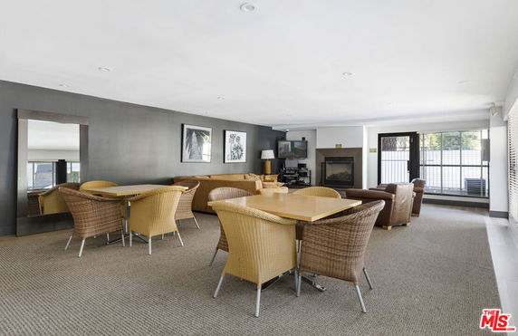 Recreation room with wicker chairs and tables, and a lounge area with a fireplace.