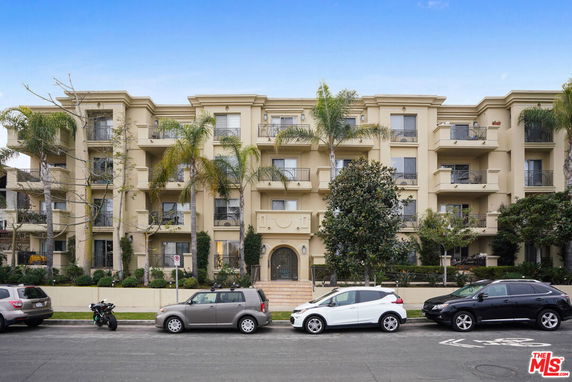 Front view of a multi-story apartment building with balconies.
