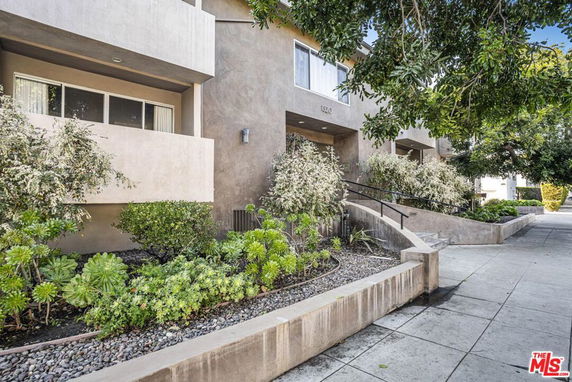 Front view of a multi-story building with a landscaped entrance.