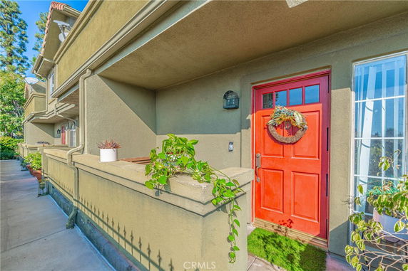 Front view of a house with a red door and balcony.