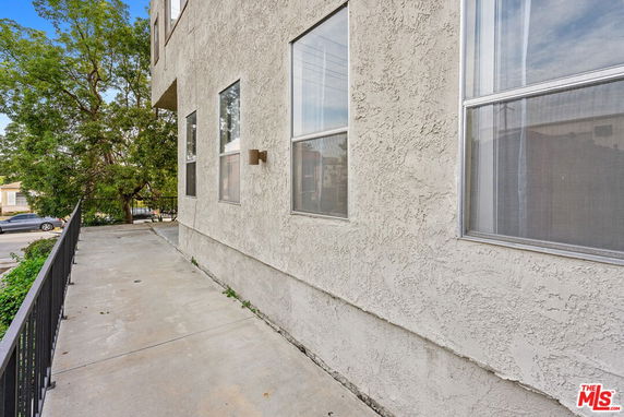 Side view of a building with multiple windows and a concrete path.