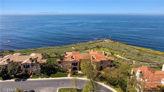 Panoramic view of a coastal area with houses and the ocean in the background.