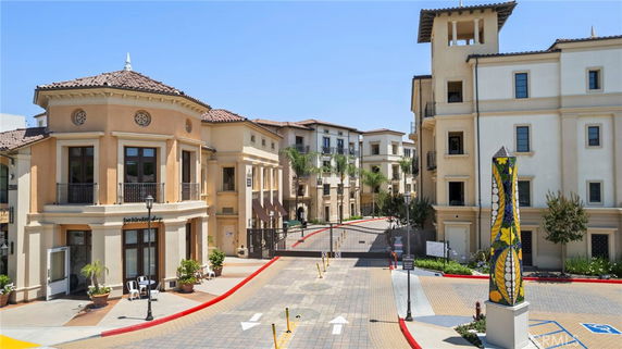 View of residential buildings with stucco exteriors and a gated entrance.