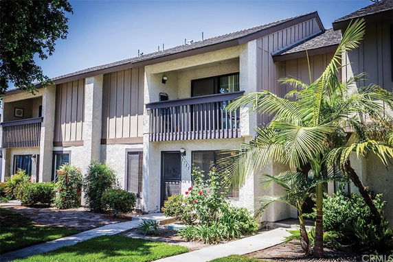 Front view of a multi-unit, two-story residential building with balconies.