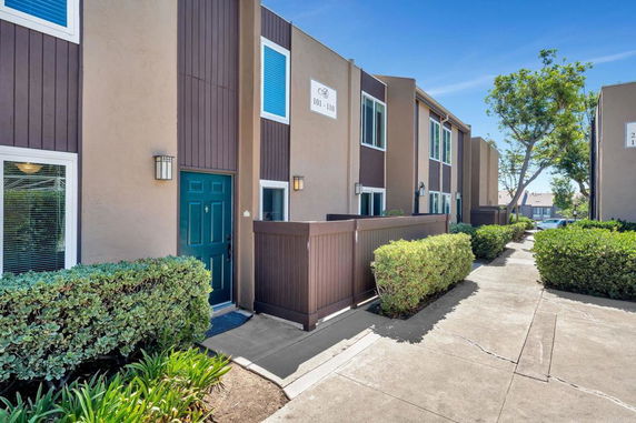 Front view of a townhouse with a pathway and greenery