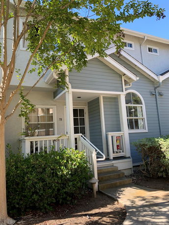 Front entrance of a two-story house with blue siding and white trim.