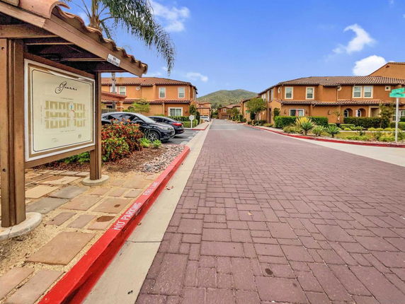 Outdoor parking area with parked cars near residential buildings.