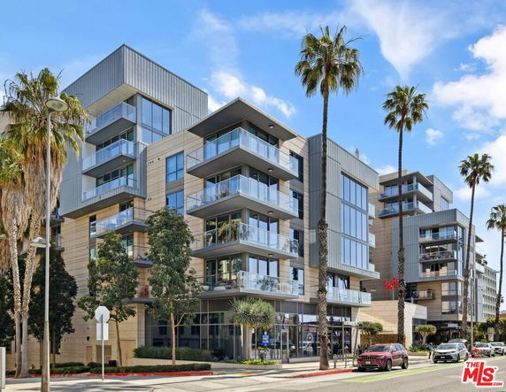 Front view of a modern multi-story building with balconies.