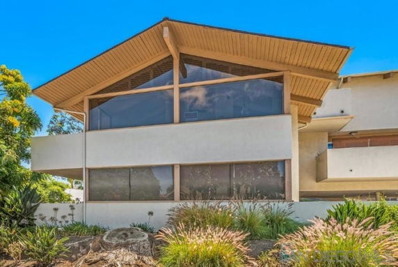 Front view of a modern two-story house with large windows and a sloped roof.