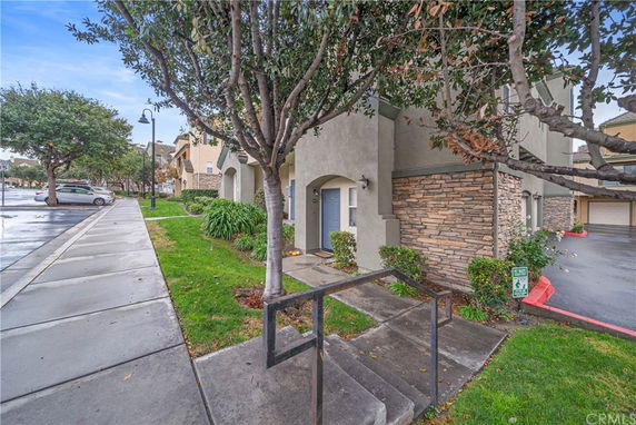 Front elevation of a multi-story building with stone accents and a blue door.