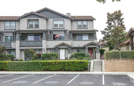 Front view of a multi-story residential building with balconies.
