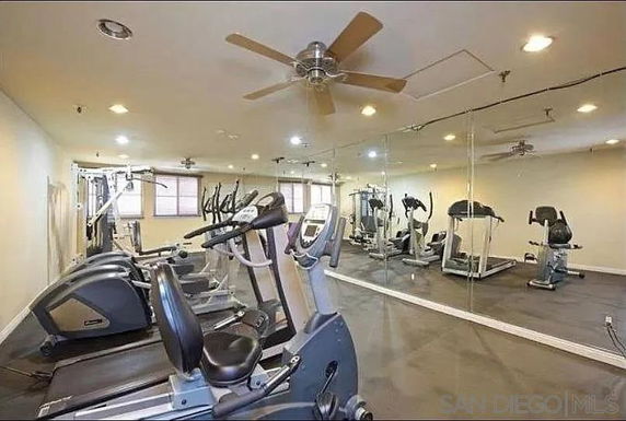 Indoor gym area with exercise equipment and large mirrors.