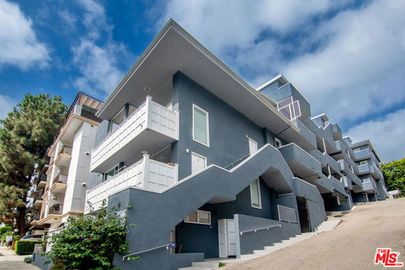 Front view of a multi-story residential building with balconies.