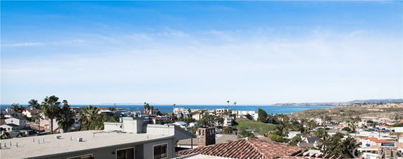 Panoramic view of coastal town with ocean in the distance.