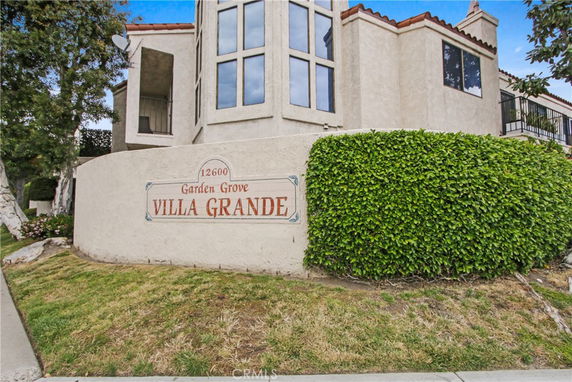 Front view of a multi-story building with large windows and a sign reading Villa Grande.