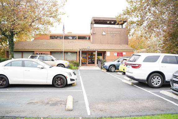 Front view of a building with a parking area in front.