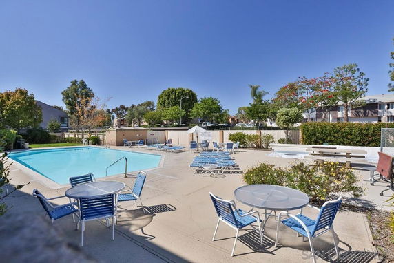 Outdoor area featuring a swimming pool with lounge chairs and tables.