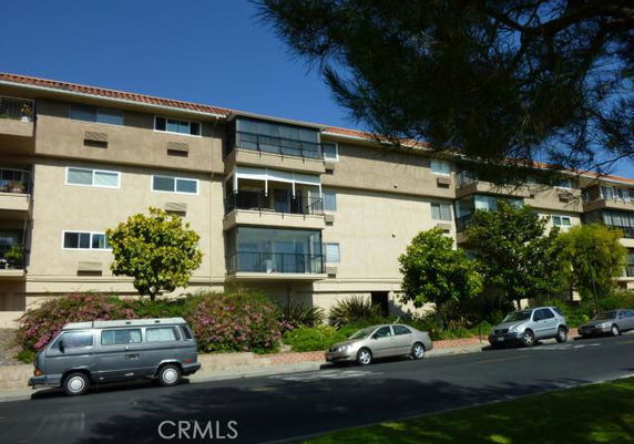 Front view of a multi-story apartment building with balconies.