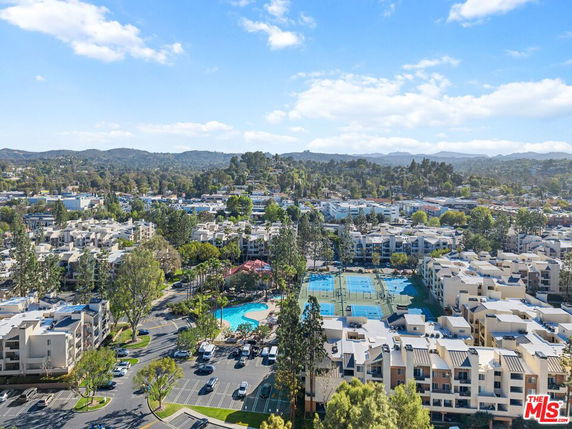 Panoramic view of residential complex with swimming pool and tennis courts.