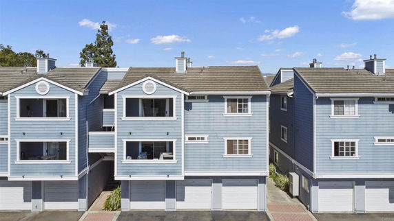 Front view of a multi-story townhouse with garages on the ground floor.