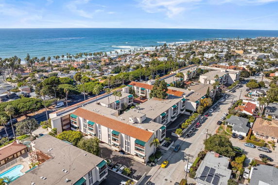 Aerial view of a coastal residential area with multiple apartment buildings and the ocean in the background.