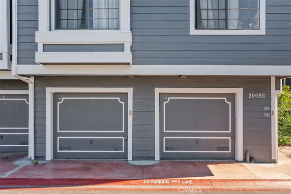 Front view of a building with two garage doors and upper windows.