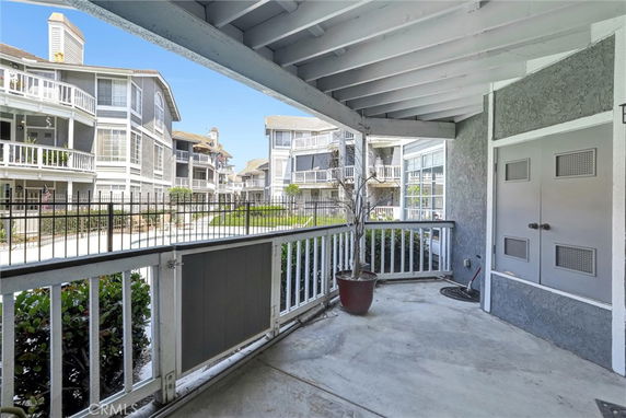 View from a covered porch overlooking adjacent residential buildings with balconies.