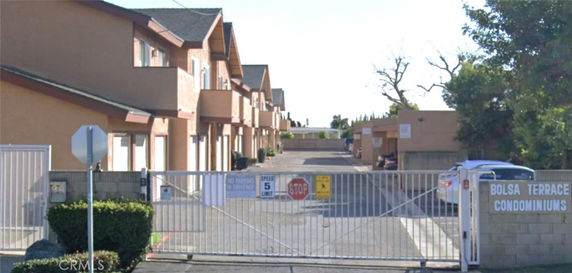 Front view of two-story condominium buildings with gated entrance
