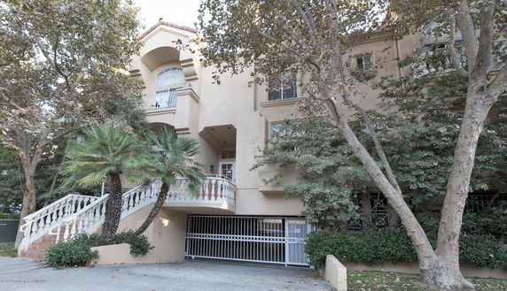 Front view of a multi-story building with gated entrance.