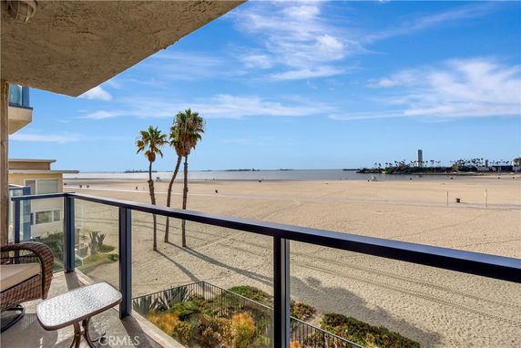 Panoramic view of sandy beach and ocean from a balcony.