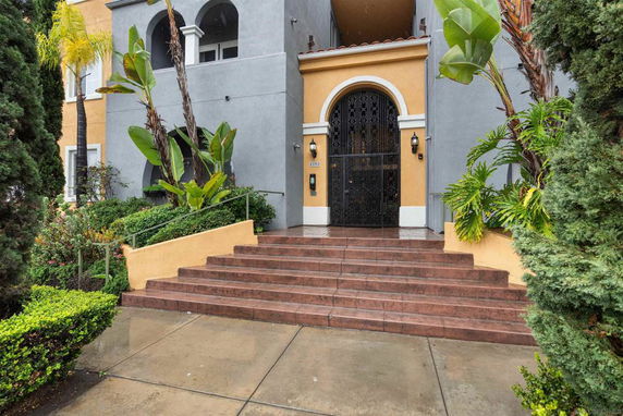 Front view of a building with arched entrance and decorative iron door.