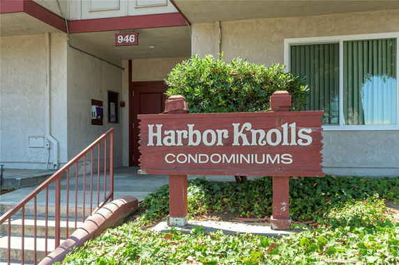 Front view of Harbor Knolls condominiums entrance with a sign and stairs.