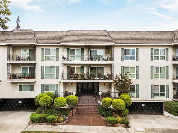 Front view of a three-story apartment building with balconies.
