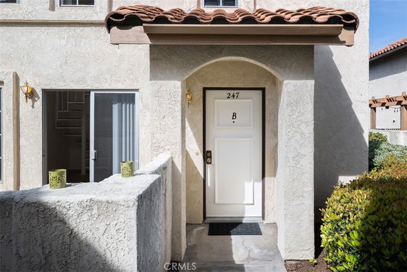 Front view of a house with a door labeled 'B' and textured walls.